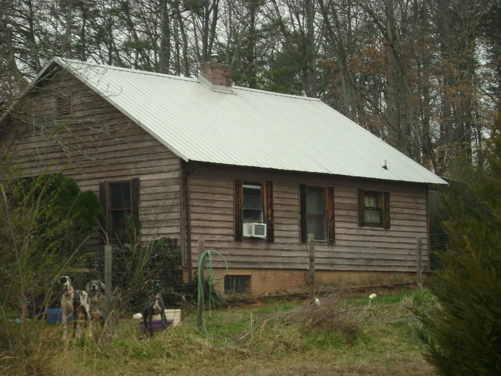 White metal roof on an old wood sided farmhouse, from a Metal Roof Installation job in Mannsville